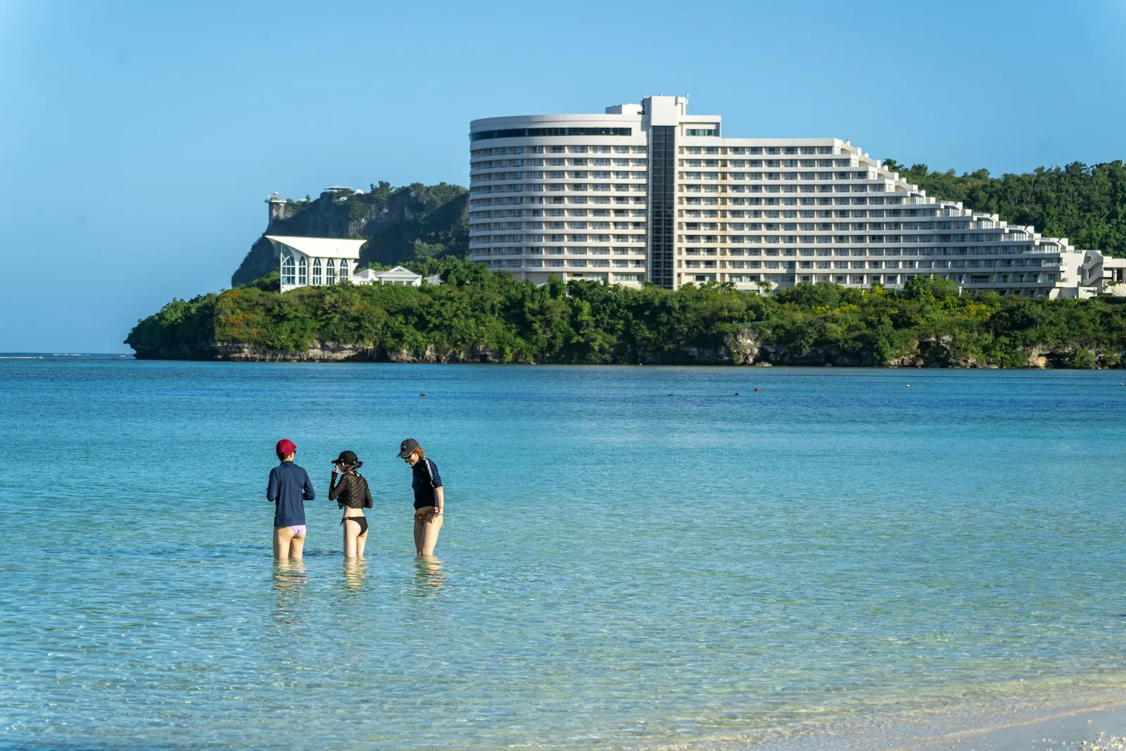 A group of people standing on top of a sandy beach